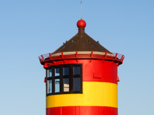 Das Bild zeigt einen friesichen Leuchtturm in den Farben Rot und Gelb.